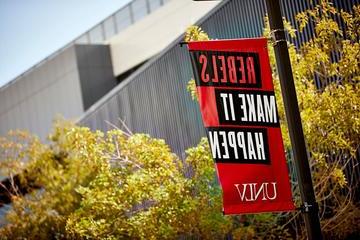 Rebels Make It Happen branded statement on signage with the U-N-L-V brand at its base, on campus.